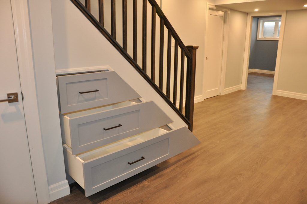 three drawers that are pulled open under a stairwell