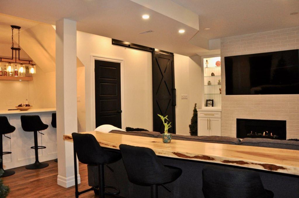 flatscreen television above a gas fireplace in a remodelled basement